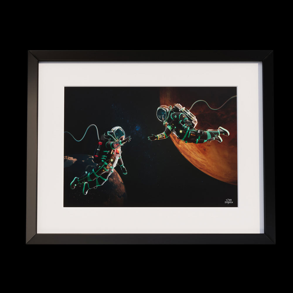 Framed artwork featuring two astronauts floating in space near a planet.