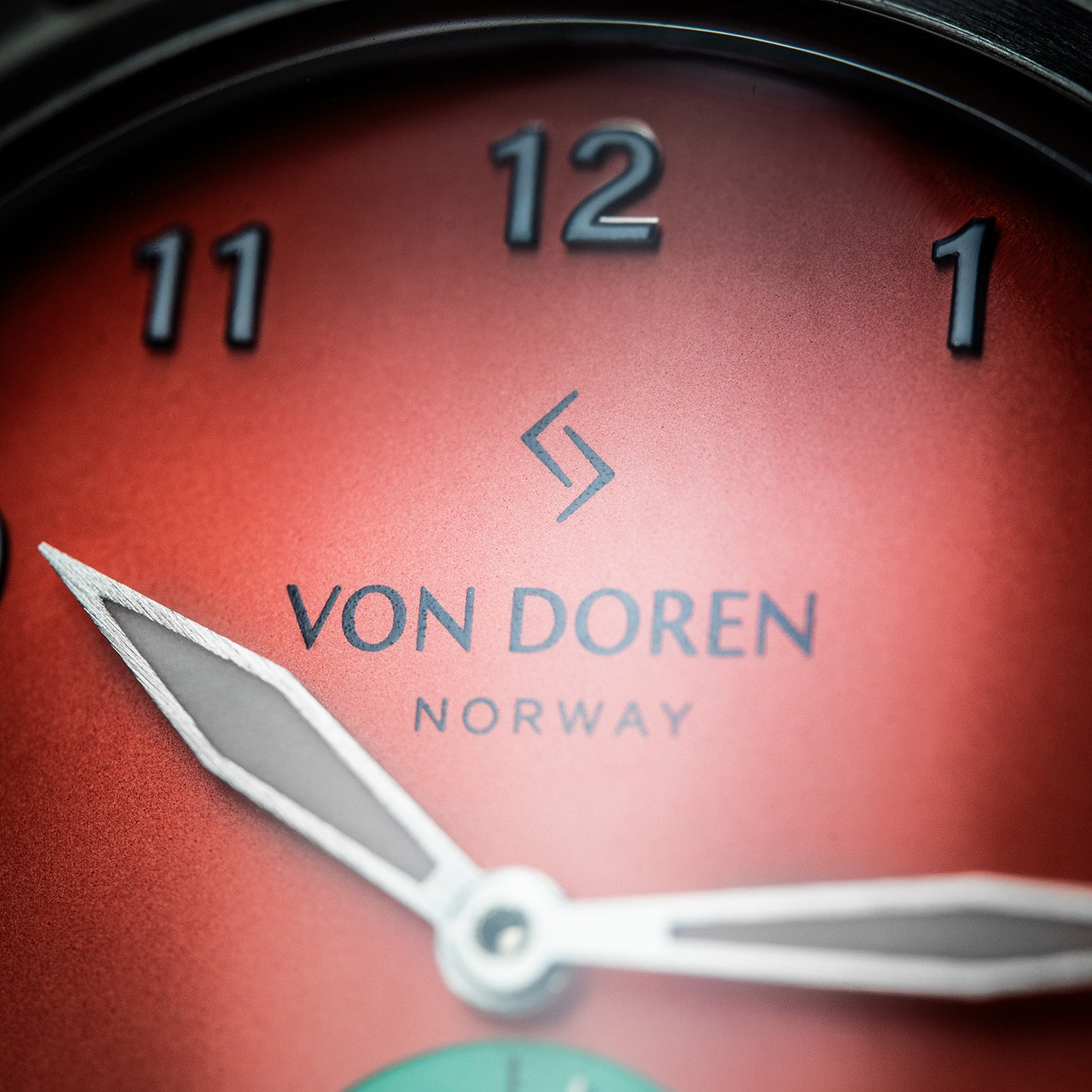 Von Doren Runde Candy Chili med rød tallskive, sølvfargede visere og opphøyde tall.