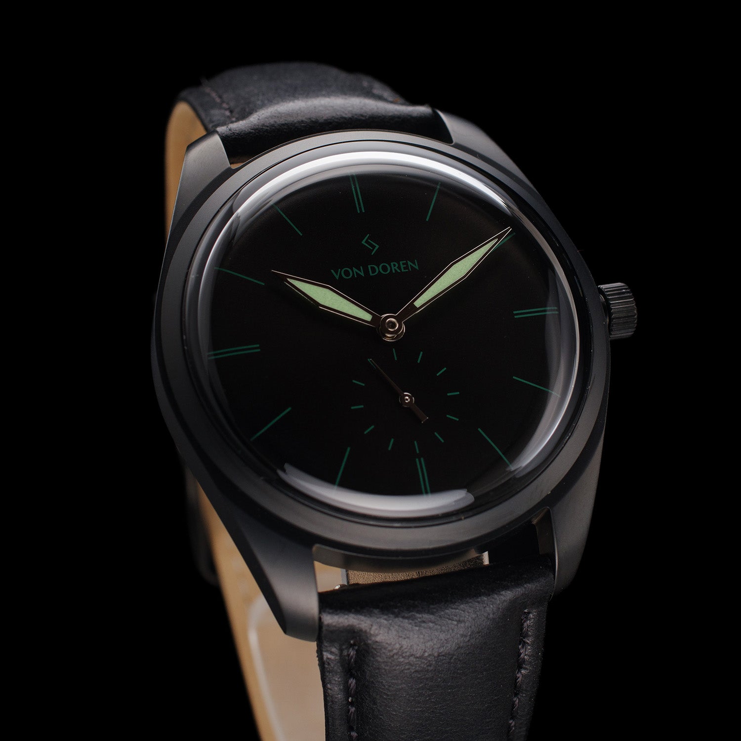 Helsort klokke. Både kasse, skiven og reimen er sort.