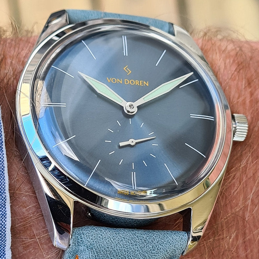 Von Doren klokke. Modell Runde farge steel blue opå arm.