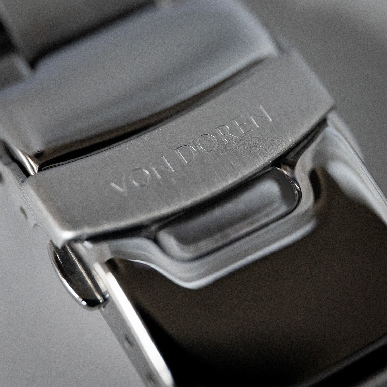 Nærbilde av stållenke med lås gravert med Von Doren-logo.