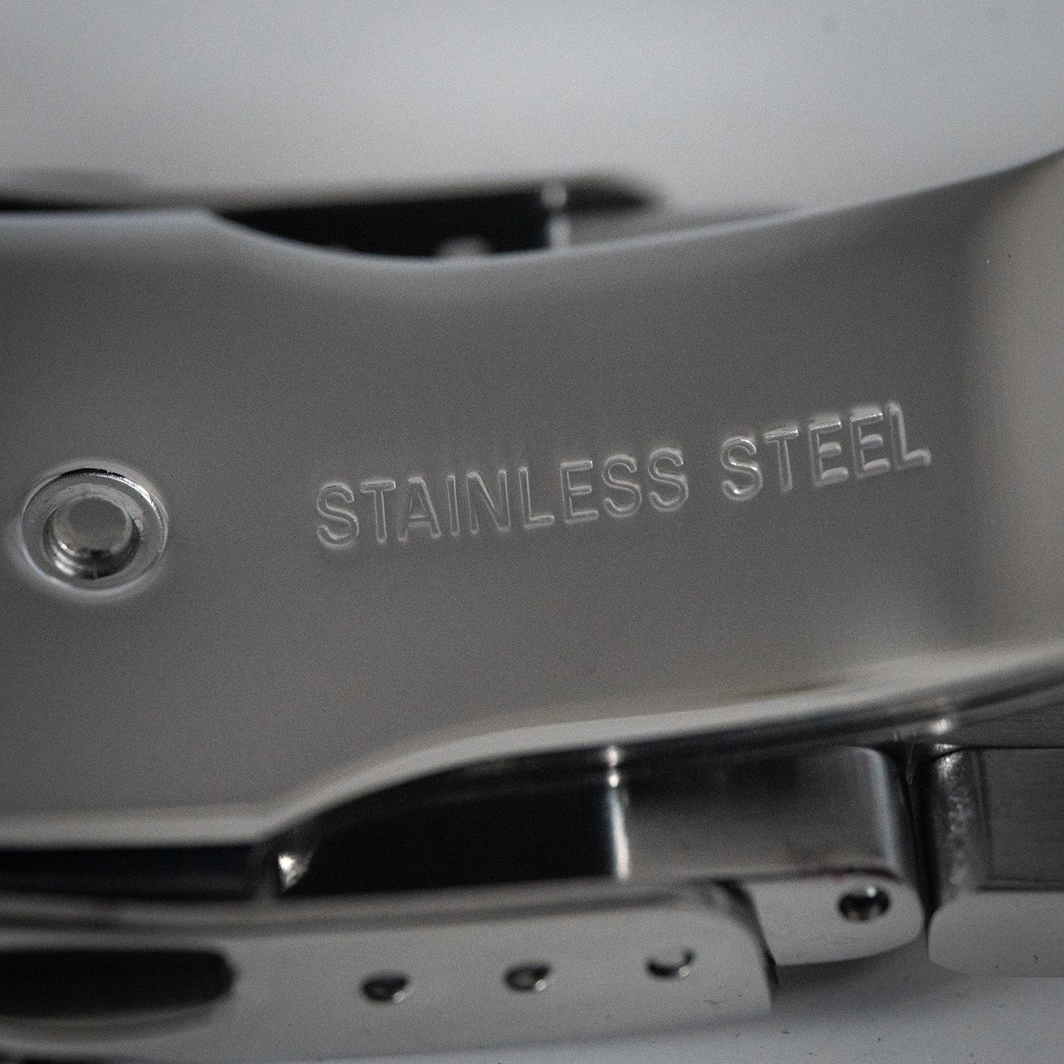 Nærbilde av stållenke med inngravert tekst ‘Stainless Steel’.