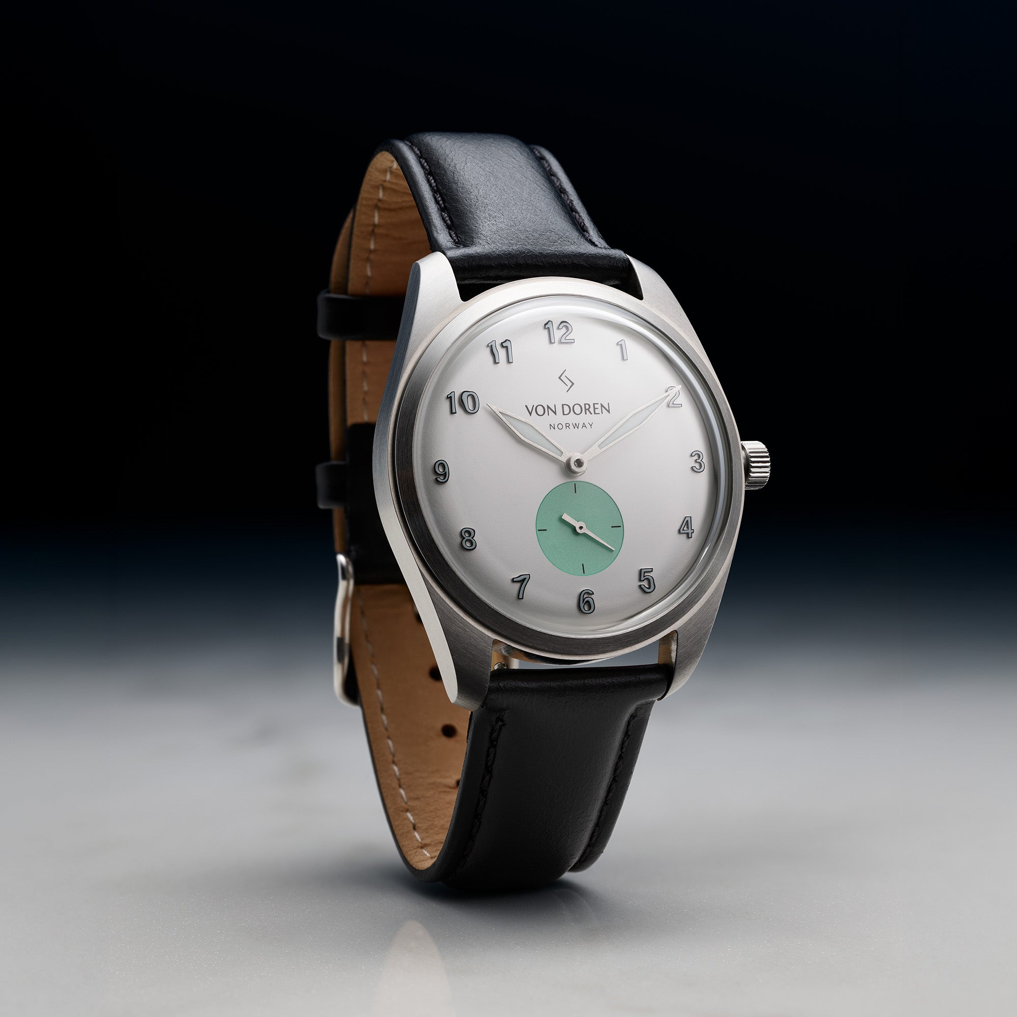 Von Doren klokke med hvit og grønn skive. Sort skinnreim