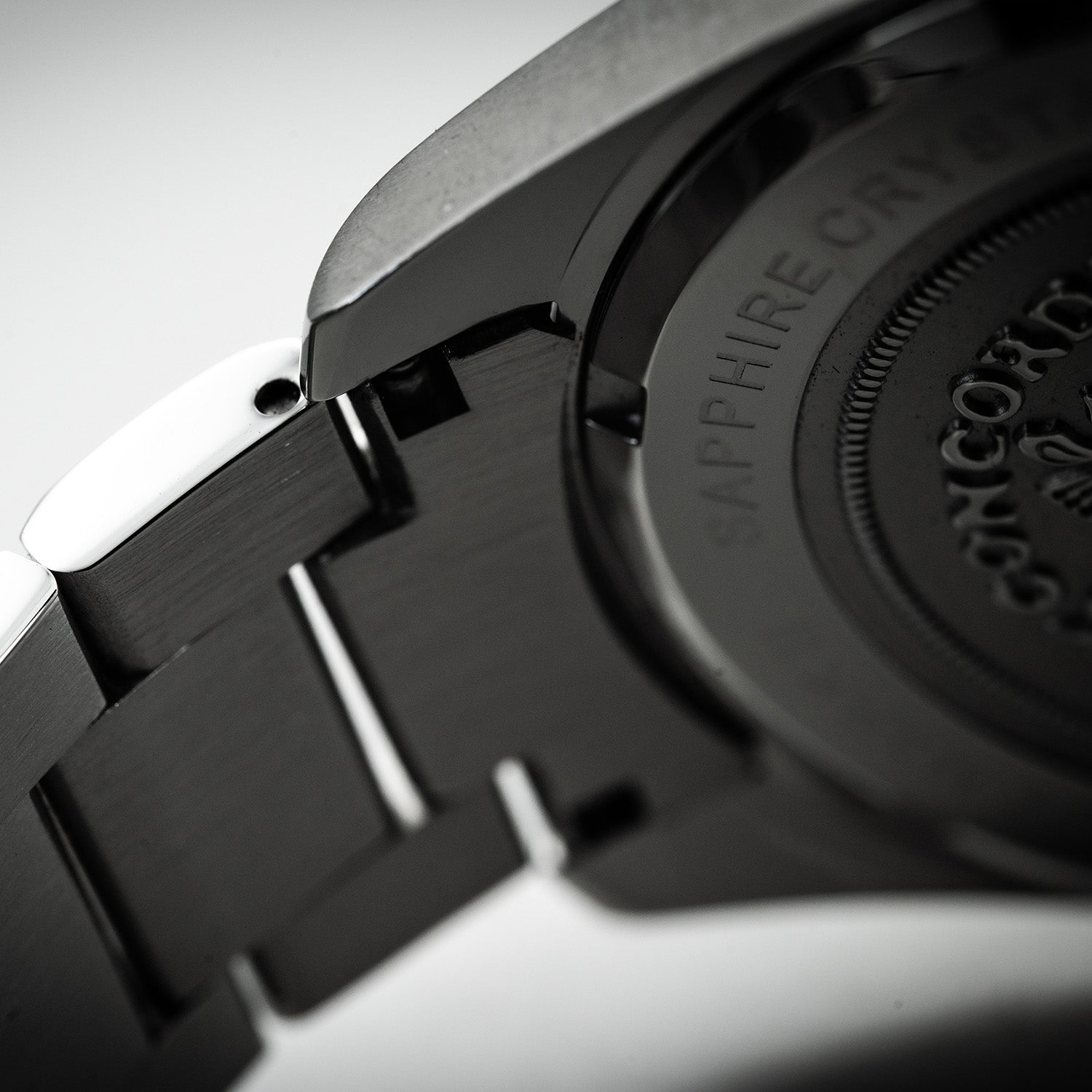 Nærbilde av klokkehus og lenke i stål med gravert baklokk.